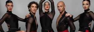 Spectacle de cabaret avec cinq artistes en costumes noirs et rouges, posant avec confiance.
