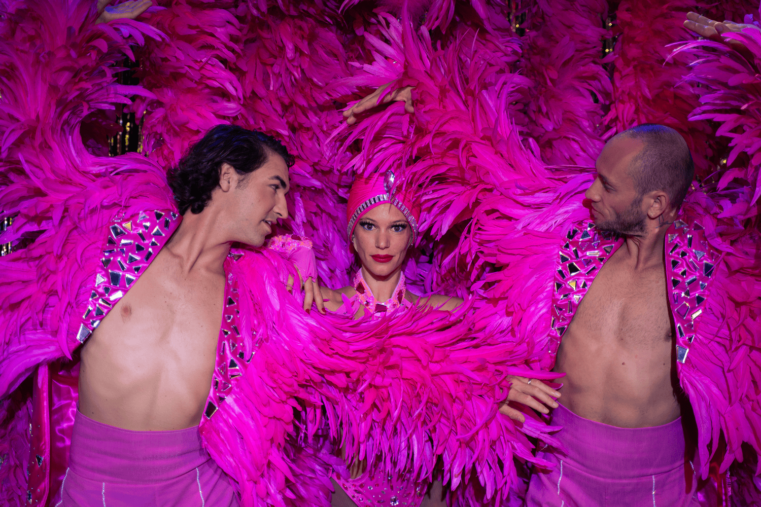 Performers en costumes colorés dans un cabaret à Marseille, scène vibrante et festive.